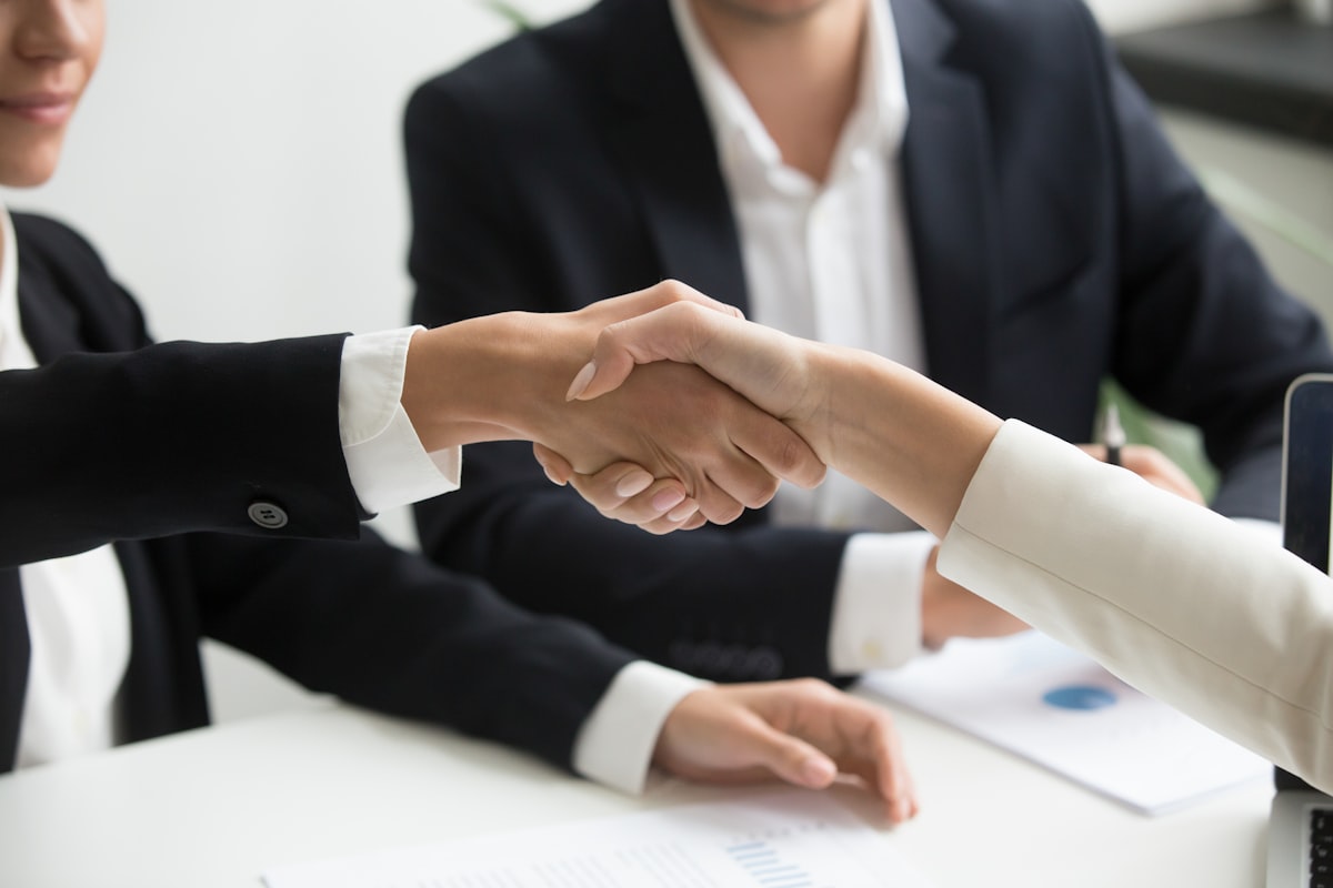 Two professionals shaking hands, representing a platform partnership